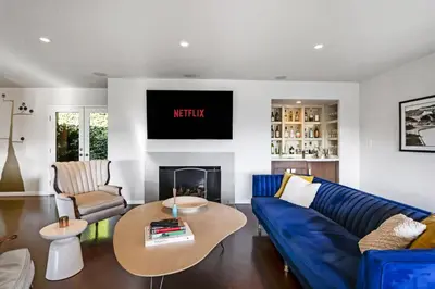 a living room with a blue couch and a tv at Hollywood Dell Oasis, Canyon VIEWS, Fire Pit and BBQ in Los Angeles