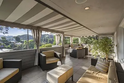 a balcony with couches and chairs and windows at Hollywood Dell Oasis, Canyon VIEWS, Fire Pit and BBQ in Los Angeles