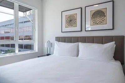 a bedroom with a white bed with two pictures on the wall at Level Olympic in Los Angeles