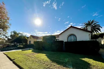a house with a yard with grass and bushes at Tranquil Comfortable 2BR Home Mid Wilshire in Los Angeles