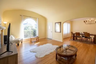 a living room with a tv and a dining room at Tranquil Comfortable 2BR Home Mid Wilshire in Los Angeles