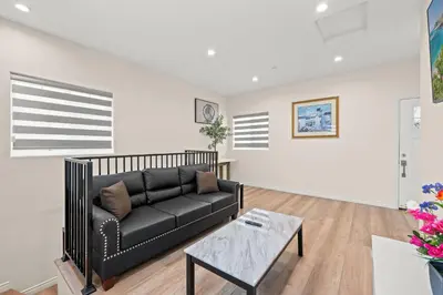 a living room with a black couch and a table at Modern Getaway Near Pasadena & DTLA in Rosemead