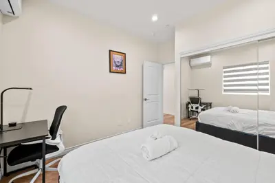 a bedroom with two beds and a desk and a desk at Modern Getaway Near Pasadena & DTLA in Rosemead