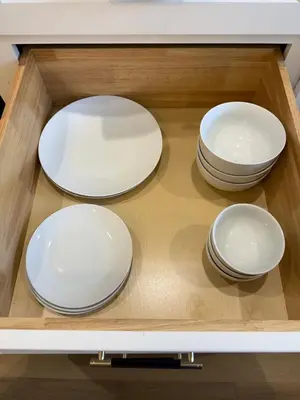 four white plates are sitting in a drawer at Charming Casita near USC, SOFI, and Culver City in Los Angeles