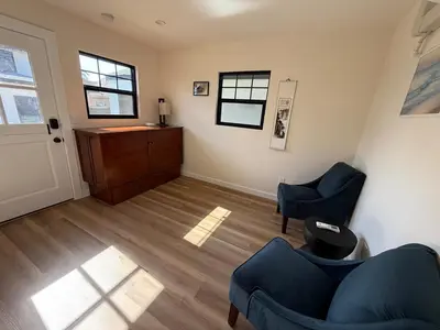 a living room with two blue chairs and a dresser at Charming Casita near USC, SOFI, and Culver City in Los Angeles
