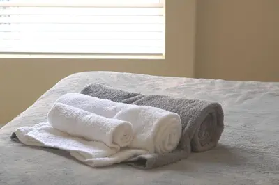 a pile of towels sitting on top of a bed at Luxe Homestay In Venice in Los Angeles