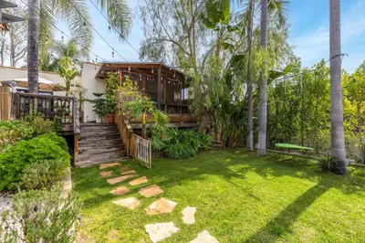 a yard with a house with palm trees at Spanish Bungalow in Trendy Los Feliz For Families in Los Angeles