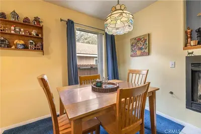 a dining room with a wooden table and chairs at The Quiz Cottage Games & BBQ Outdoor Area! in Big Bear Lake