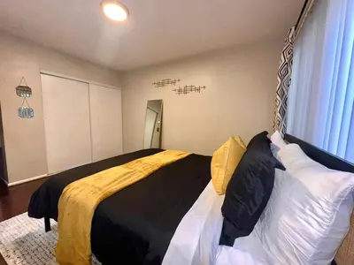 a bedroom with a bed with black and white pillows at Cozy home in Franklin Village, Central location! in Los Angeles
