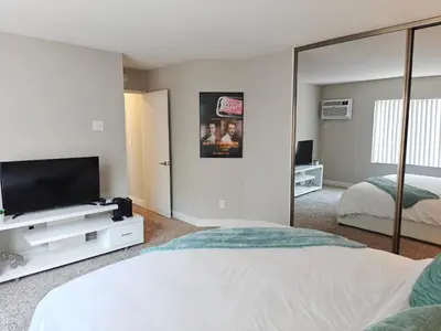 a bedroom with a tv and a mirror at Skyline Escape 1-Bedroom with Balcony and Roof-Top Pool in Los Angeles