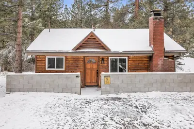 a log home with a snow covered roof at Sueños Azules- Fawnskin Retreat Cottage in Big Bear in Fawnskin