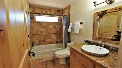 a bathroom with a sink and a toilet and a tub at Lakeside Oasis in Big Bear Lake