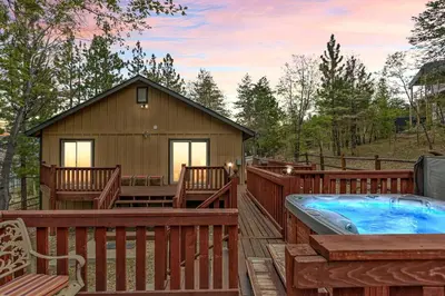 a hot tub on a deck next to a house at Sea to Ski Retreat in Big Bear Lake