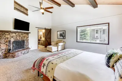 a bedroom with a large bed and a fireplace at Private Hot Tub at Dog-Friendly Lake Arrowhead Gem in Lake Arrowhead