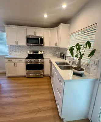 a kitchen with white cabinets and a potted plant at PRIVATE modern studio Guesthouse in Los Angeles