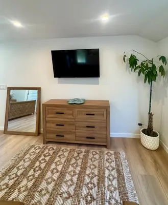 a room with a dresser and a tv on a wall at PRIVATE modern studio Guesthouse in Los Angeles