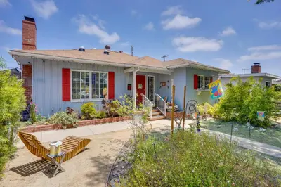 a white house with a red door at 2 Mi to Cal State Long Beach Bungalow with Hot Tub! in Long Beach