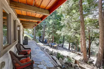 an outdoor patio with chairs and a table and trees at Walk to Lake Gregory Family Retreat with Patio! in Crestline