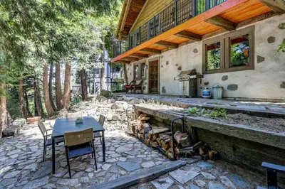 a patio with a table and chairs and a house at Walk to Lake Gregory Family Retreat with Patio! in Crestline