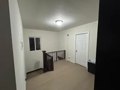 an empty hallway with a staircase and a white door at Hollywood Home in Los Angeles
