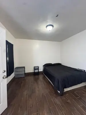 a bedroom with a bed and a wooden floor at Hollywood Home in Los Angeles