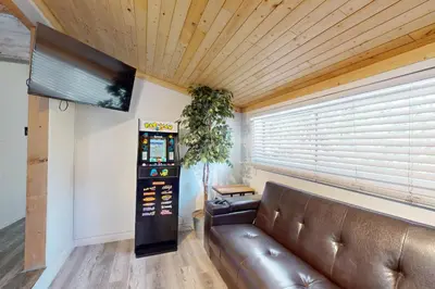 a living room with a leather couch and a television at Elevation Escape in Lake Arrowhead