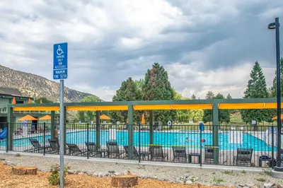 a swimming pool with chairs and a sign next to it at Mountain-View Haven with Deck in Pine Mountain Club in Frazier Park