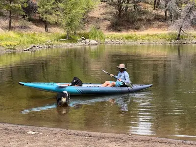 a man in a kayak on a river with a dog at Serene Lakefront Escape in LA in Lake Hughes