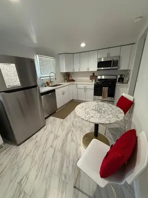 a kitchen with a table and two chairs and a table and a refrigerator at Serene Lakefront Escape in LA in Lake Hughes