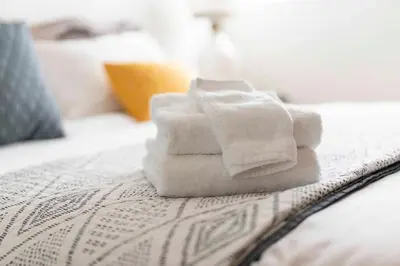 a pile of towels sitting on top of a bed at New Renovated 3B2B house in West Covina