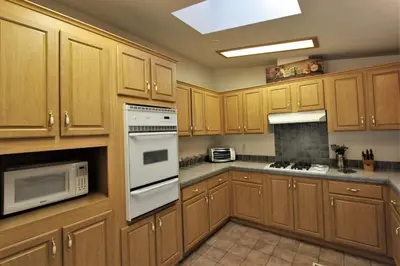 a kitchen with wooden cabinets and white appliances at Bluebird Cottage in Big Bear Lake