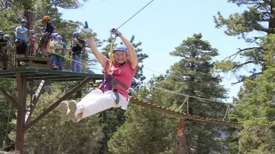 a woman on a zip line in the trees at Hot Tub, Near Village/Lake - Kelly`s Kottage in Big Bear Lake
