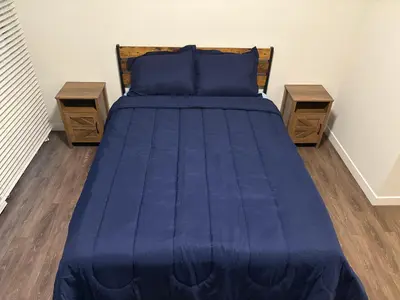 a bed with blue sheets and two night stands at Poolside Palace in Los Angeles