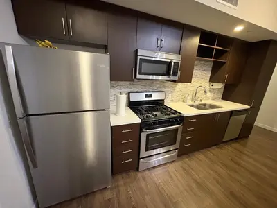 a kitchen with a stainless steel refrigerator and a microwave at Poolside Palace in Los Angeles