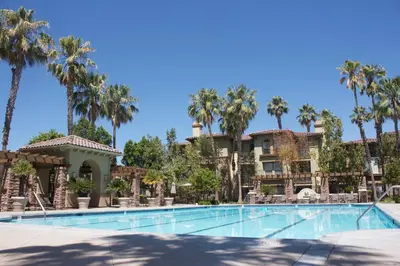 a resort with a swimming pool and palm trees at Luxury 3 Bedroom Apartment in Santa Clarita