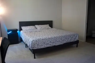 a bedroom with a bed with a black frame and pillows at Luxury 3 Bedroom Apartment in Santa Clarita