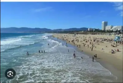 a large group of people on a beach at By The Coast Living in Santa Monica Pier Promenade in Los Angeles