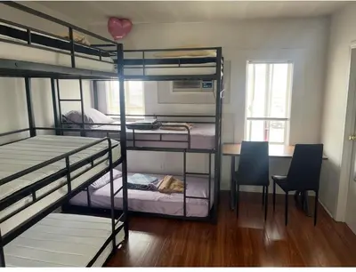 a room with three bunk beds and a table and chairs at Females room bunk beds in Los Angeles