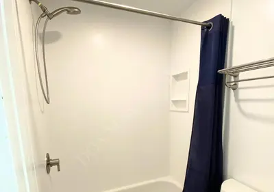 a shower in a bathroom with a blue shower curtain at Luxury condo in the heart of LA in Los Angeles