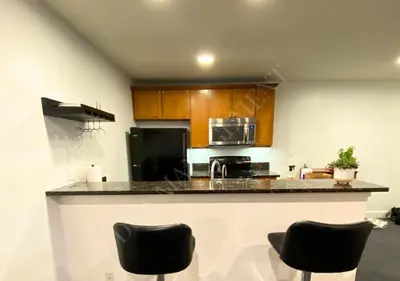 a kitchen with a counter and some black chairs at Luxury condo in the heart of LA in Los Angeles