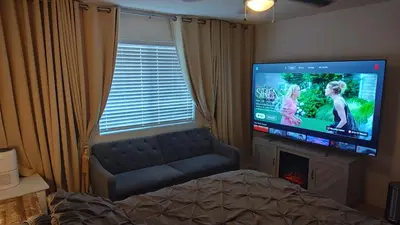 a living room with a flat screen tv and a couch at Golden House in Santa Clarita