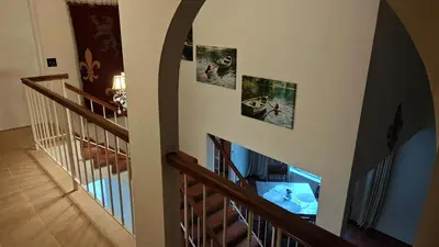 a hallway with a staircase with pictures on the wall at Golden House in Santa Clarita