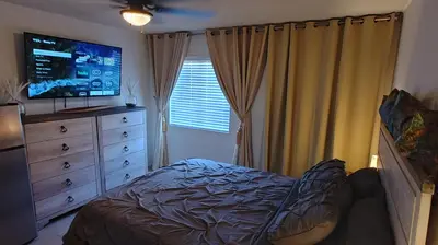 a bedroom with a bed and a dresser with a television at Golden House in Santa Clarita