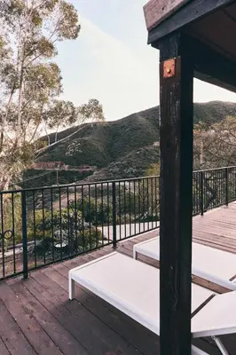 a porch with a white bench on a wooden deck at Malibu ranch retreat in Malibu