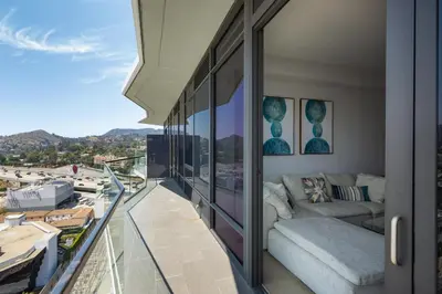 a living room with a couch on a balcony at Seven Mile Penthouse Dream Hollywood View Pool in Los Angeles