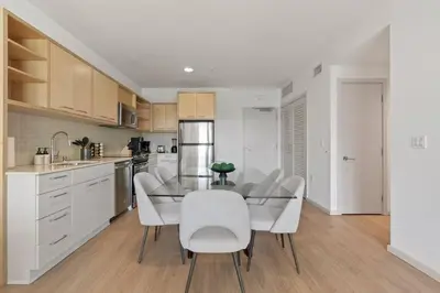 a kitchen with a glass table and white chairs at Emerald Ridge - Luxe Hollywood Walk of Fame in Los Angeles