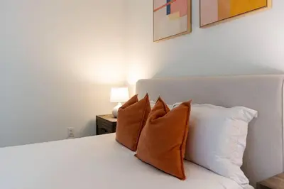 a bedroom with a white bed with four pillows at Emerald Ridge - Luxe Hollywood Walk of Fame in Los Angeles