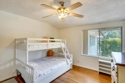 a bedroom with a white bunk bed and a ceiling fan at 12 Mi to Dtwn LA Family Home with Patio and Yard! in Downey