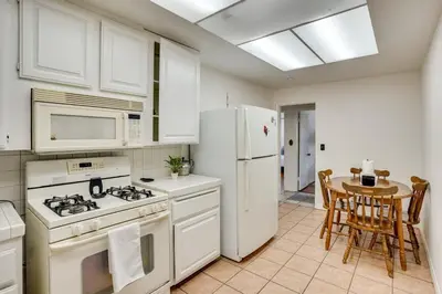 a kitchen with white appliances and a table with chairs at 12 Mi to Dtwn LA Family Home with Patio and Yard! in Downey