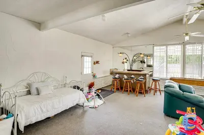 a bedroom with a bed and a living room at 12 Mi to Dtwn LA Family Home with Patio and Yard! in Downey